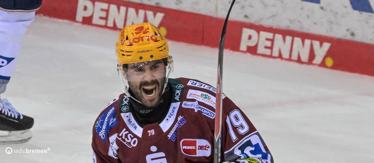 An ice hockey player cheers and opens his mouth