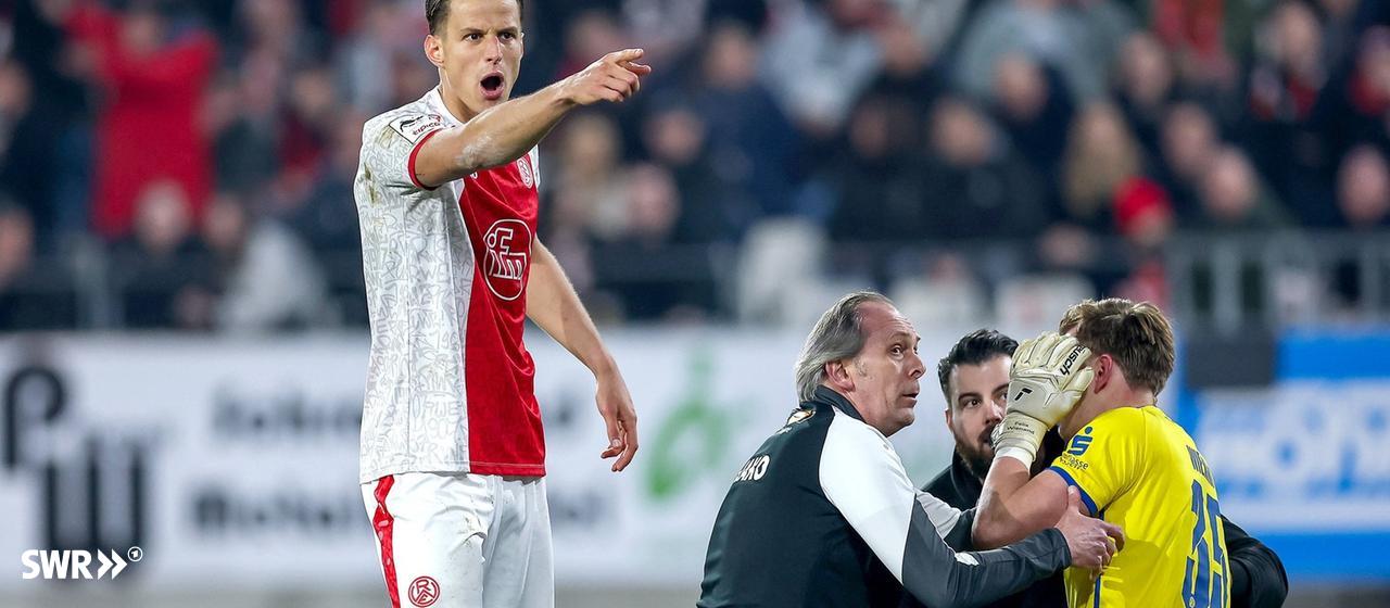 Goalkeeper Felix Wienand (Rot-Weiss Essen, right) kneels injured on the pitch in the game against Waldhof