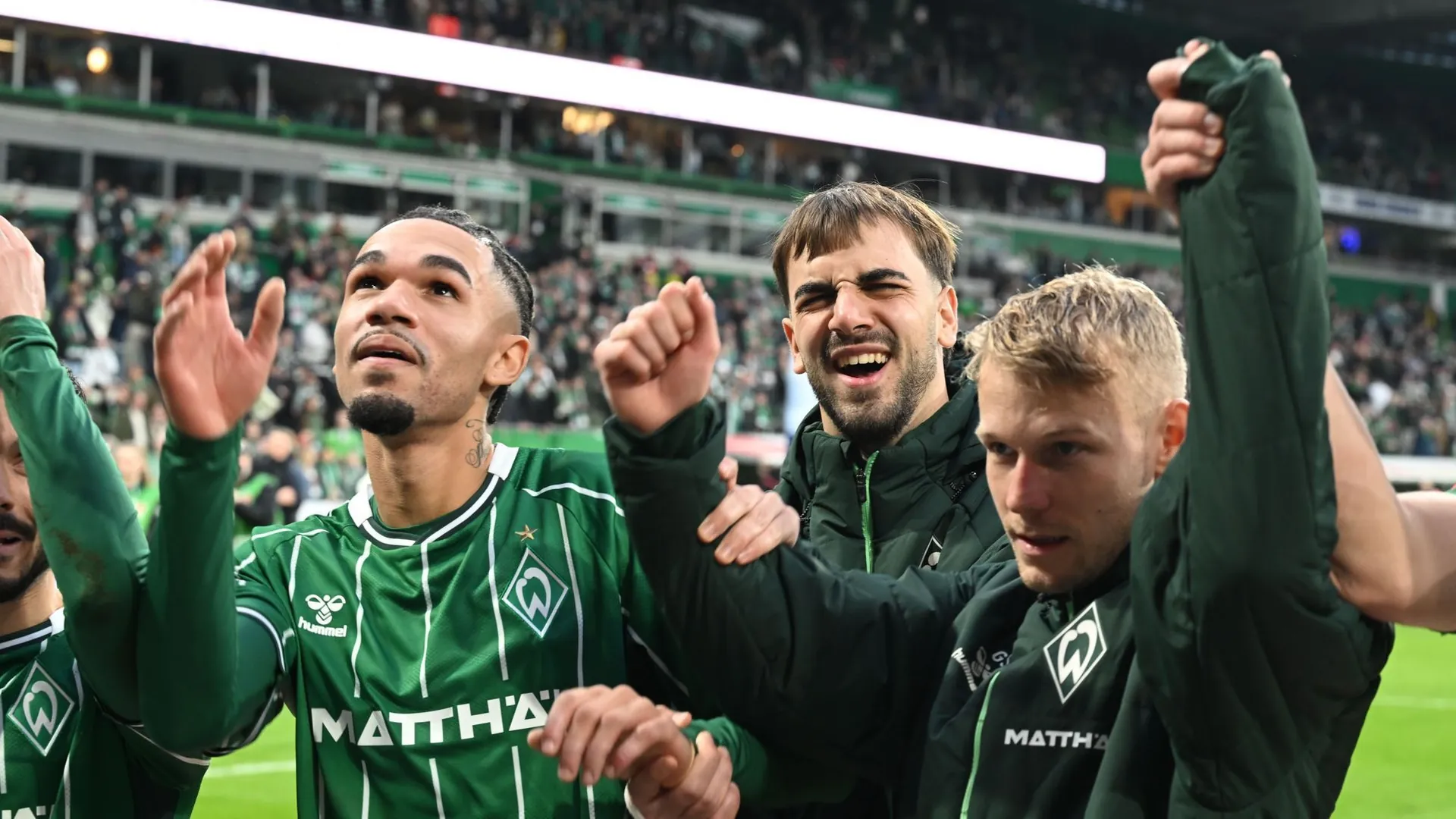 The two goal scorers Justin Njinmah (l) and Jovan Milosevic (M) as well as Marco Grüll celebrate with the fans. The two goal scorers Justin Njinmah (l) and Jovan Milosevic (M) as well as Marco Grüll celebrate with the fans.