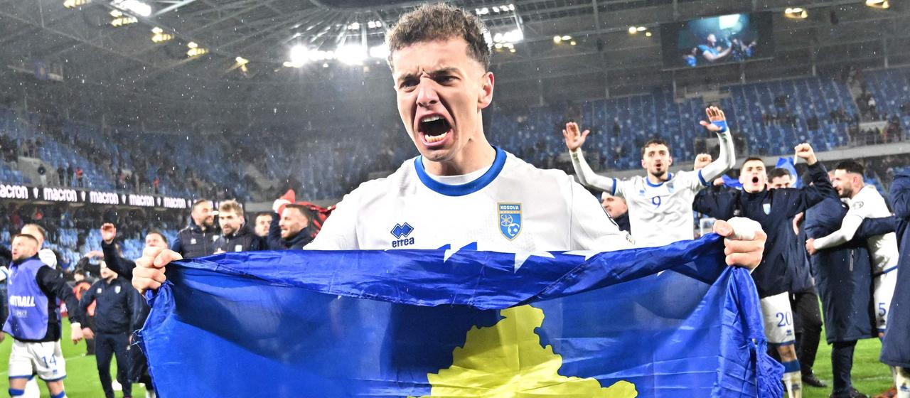 Fisnik Asllani cheers with the flag of Kosovo