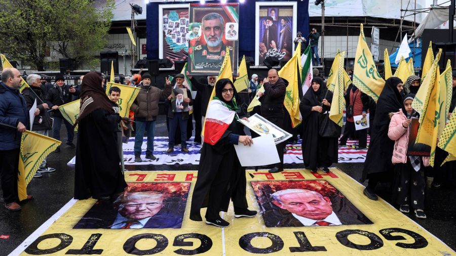 Photogallery An Iranian woman walks over posters with images of US President Donald Trump and Israeli Prime Minister Benjamin Netanyahu while participating in the demonstration