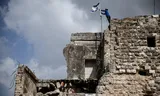 An Israeli settler places an Israeli flag on Sunday on the day of the re-establishment of the Sa-Nur settlement in the Israeli-occupied West Bank. Sa-Nur was evacuated in 2005 as part of the Israeli withdrawal.