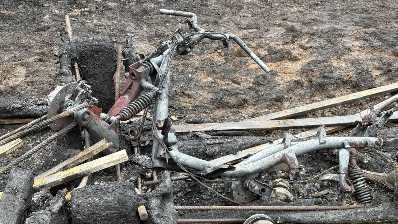The remains of a scooter lie between the blackened bridge parts. Local residents suspect that it was used in the fire (photo: Wilco Zonneveld).
