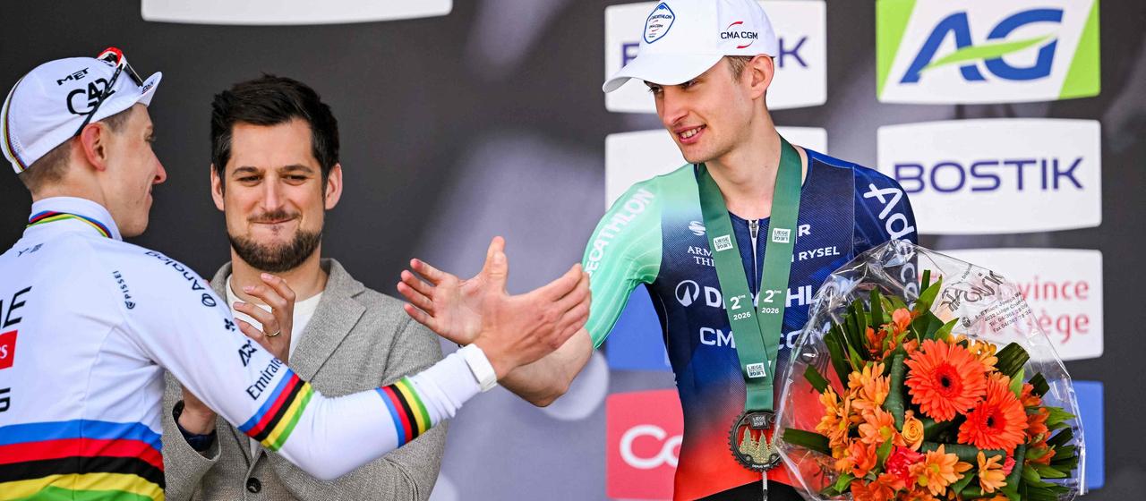Paul Seixas and Tadej Pogacar shake hands on the podium