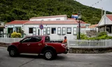 A man in the back of a pickup truck in Windwardside, a village on Saba. Photo Robin van Lonkhuijsen / ANP