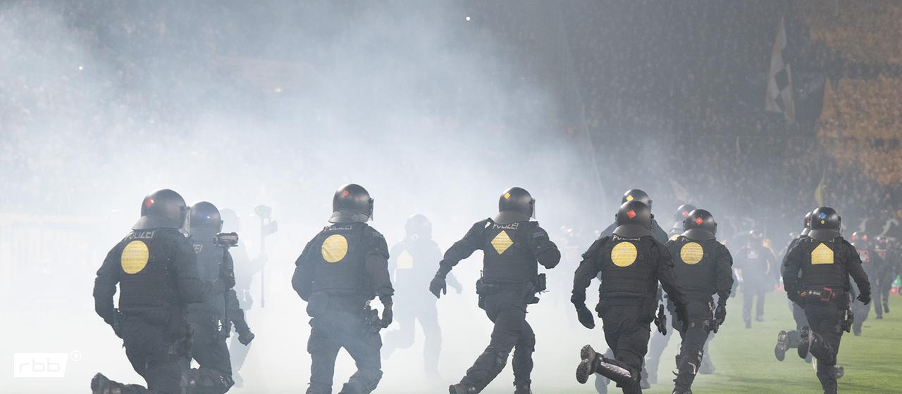 Police officers push Dynamo Dresden fans back towards the home corner. Source: dpa/Sebastian Kahnert