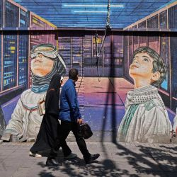 Several people walk next to a mural on the sidewalk in Tehran. The speaker of the Iranian Parliament, Mohammad Bagher Ghalibaf, who participated in peace talks with the United States this weekend, declared that Washington was "unable" to gain Tehran's trust during negotiations. | Photo:ATTA KENARE / AFP