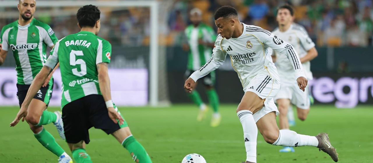 Kylian Mbappe is defended by Marc Bartra while dribbling