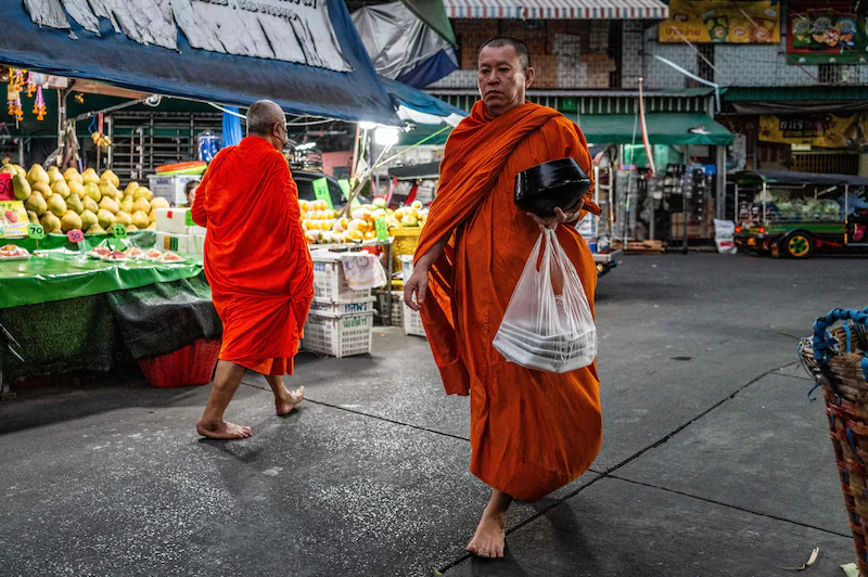 Boeddhist monniks at a market in Bangkok. Illustratiebeeld.