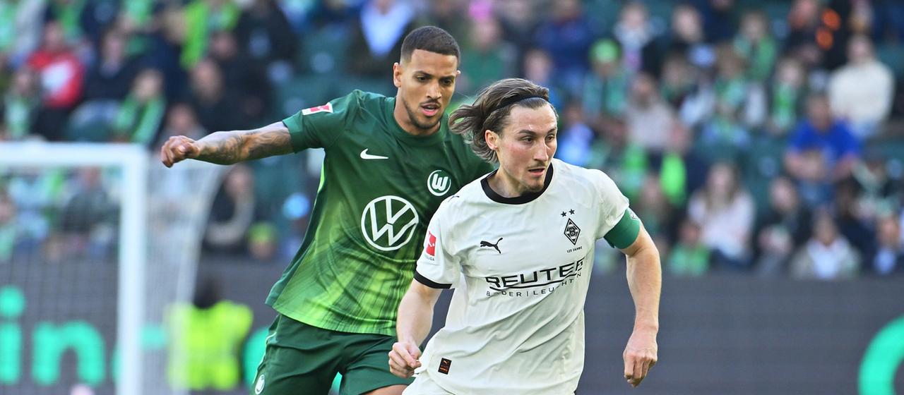 Gladbach's Rocco Reitz (from) dribbles past Wolfsburg's Vinicius Souza