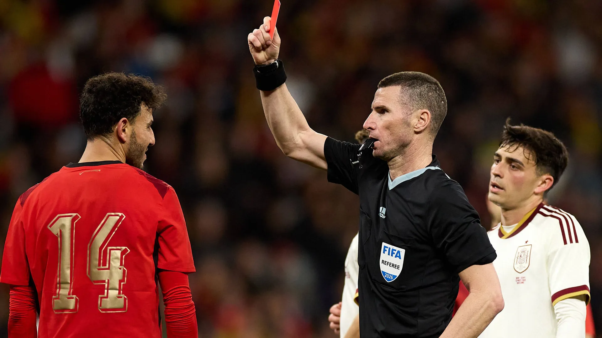 A referee (M.) shows the red card: The player who sees red must leave the field early. A referee (M.) shows the red card: The player who sees red must leave the field early.