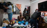 Agents of the anti-narcotics brigade search a house in the port city of Guayaquil. Handcuffed on the bed, their arrestee Julio A. is said to be selling drugs from his home for the Los Carniceros gang.