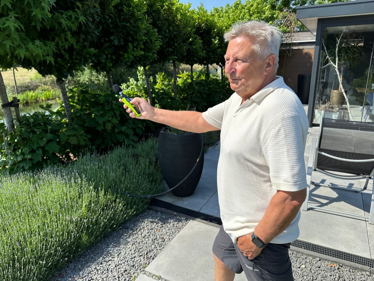 Ed Graman in his garden with a decibel meter.