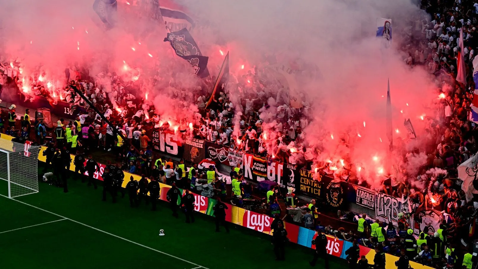 Lost control: PSG fans set off pyrotechnics after the equalizer against Arsenal, and Budapest police forces lined up in front of it.