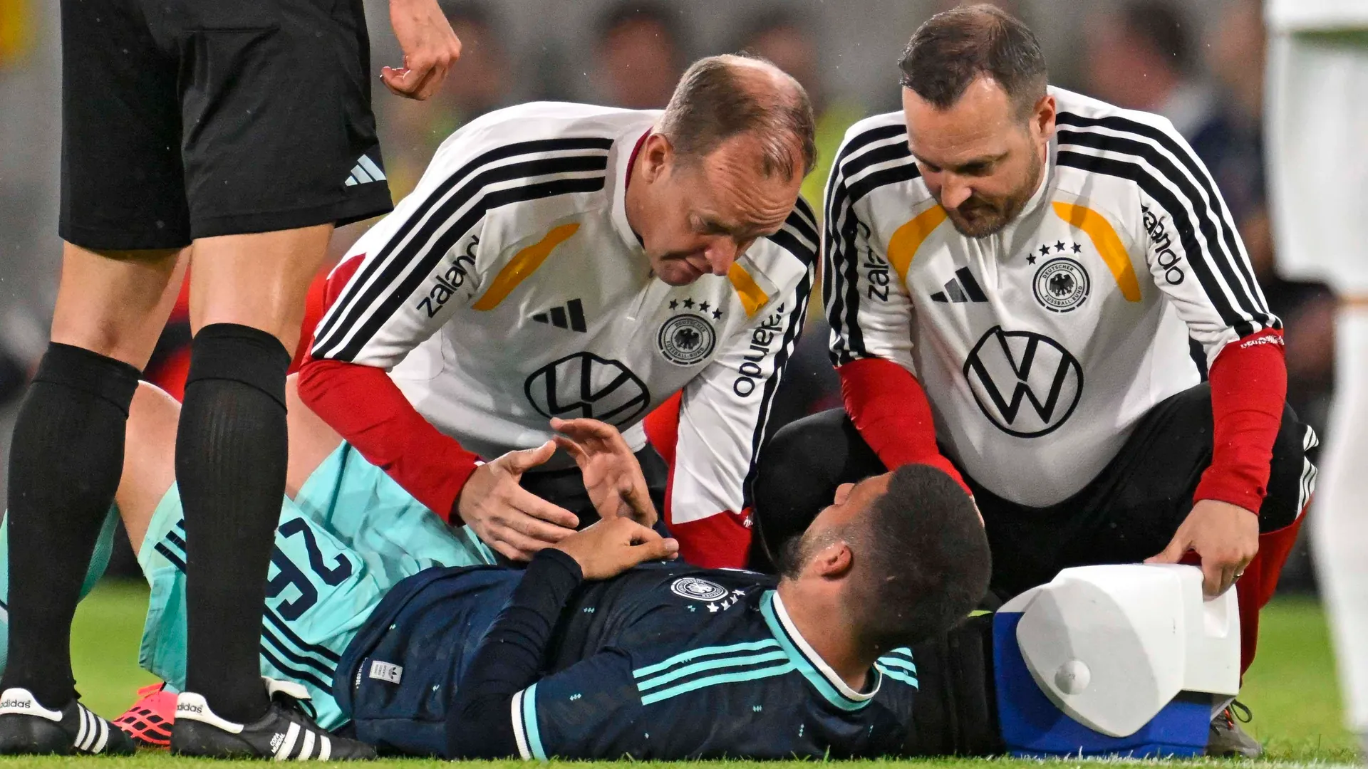 Worried looks: DFB striker Deniz Undav is treated on the pitch.