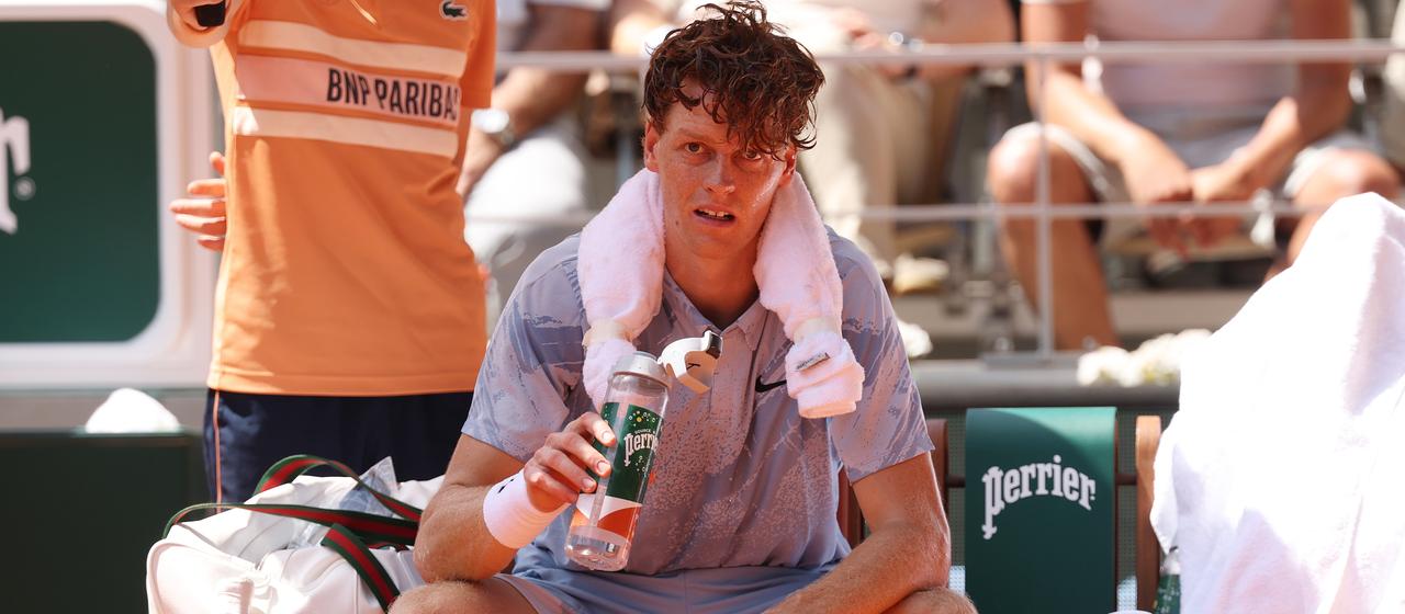 Jannik Sinner sits exhausted on the bench during his second round match