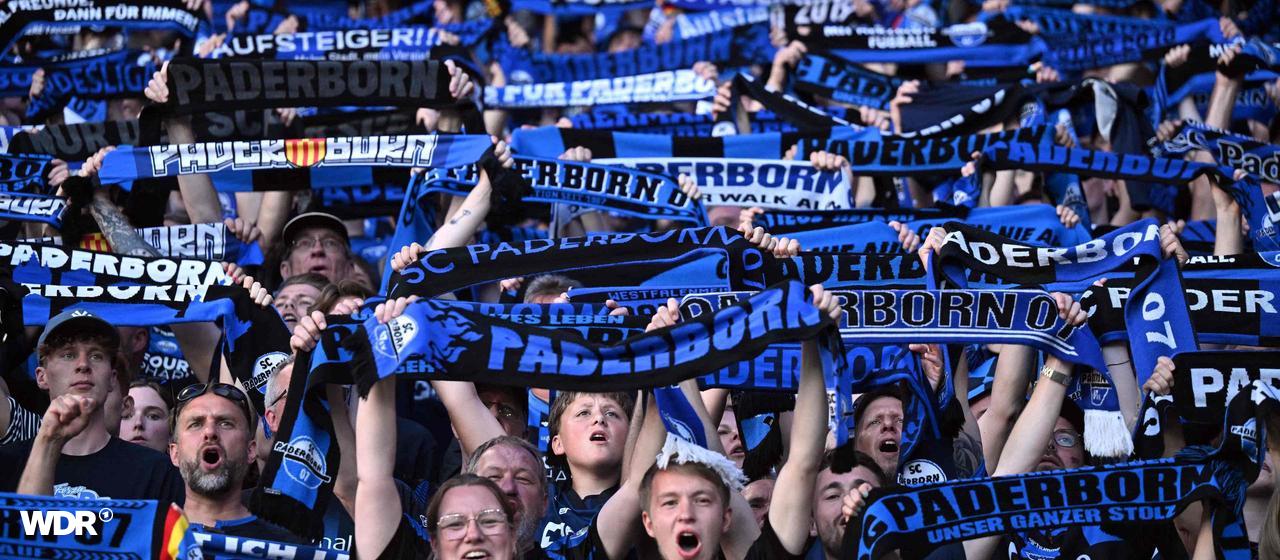 SC Paderborn fans hold up scarves during the game