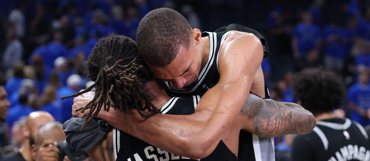 Victor Wembanyama (h.) hugs Devin Vassell (v.)