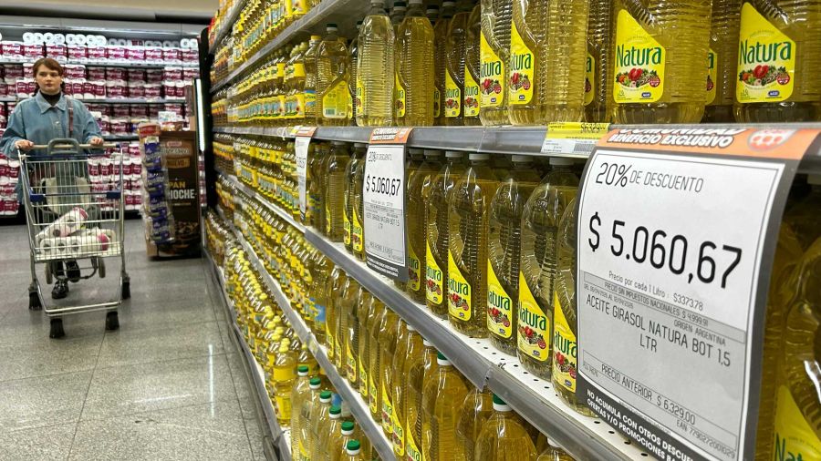 Photogallery A woman pushes a shopping cart in front of a stand selling sunflower oil for sale in a supermarket in Buenos Aires