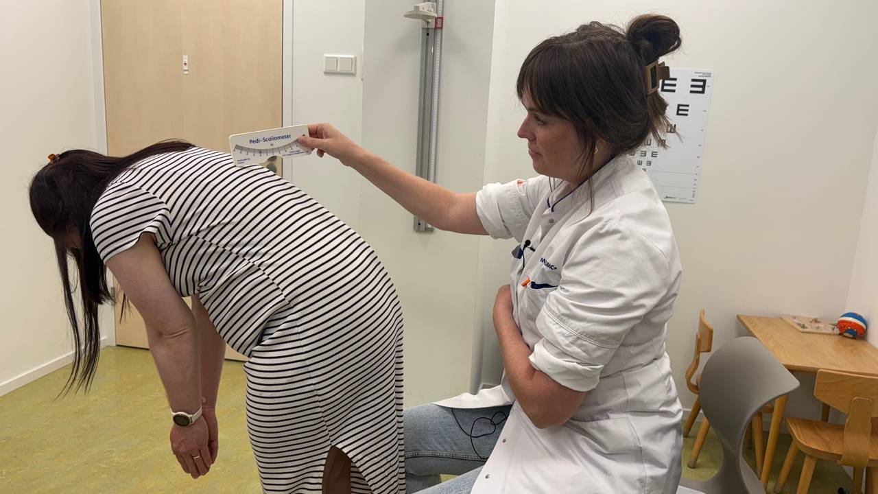 During a bend test, orthopedic surgeon Eva Jacobs (right) measures with a ruler how crooked the back grows (photo: Omroep Brabant).
