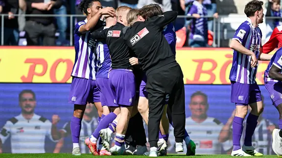 Osnabrück's players cheer with coach Timo Schultz.