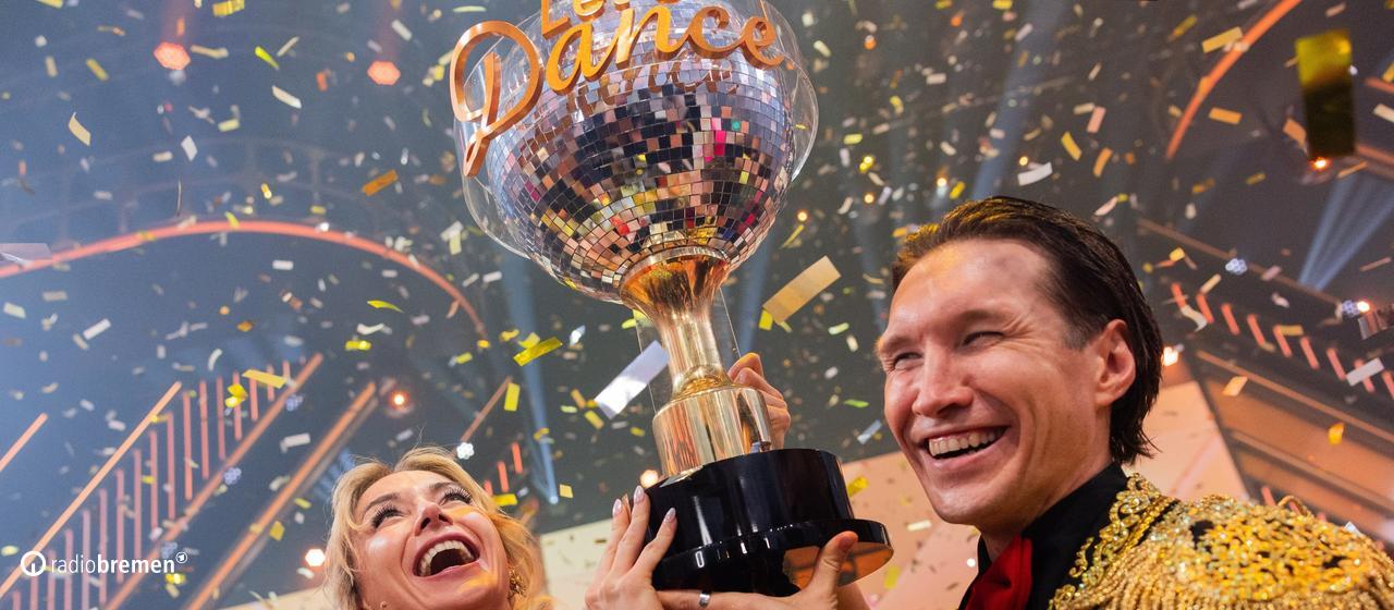 The Bremen professional dancer Evgeny Vinokurov shines with the winner's trophy of the dance show "Let's Dance" next to his dance partner Anna-Carina Woitschak.