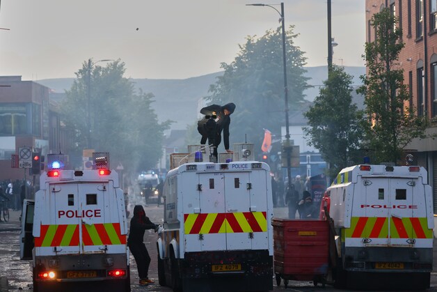 Demonstrators attack police vans.