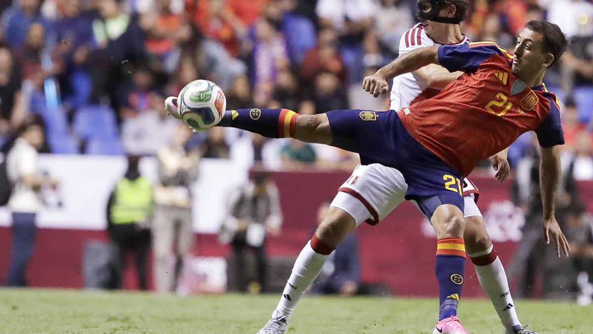 Mikel Oyarzabal of Spain disputes the ball with Fabio Gruber of Peru