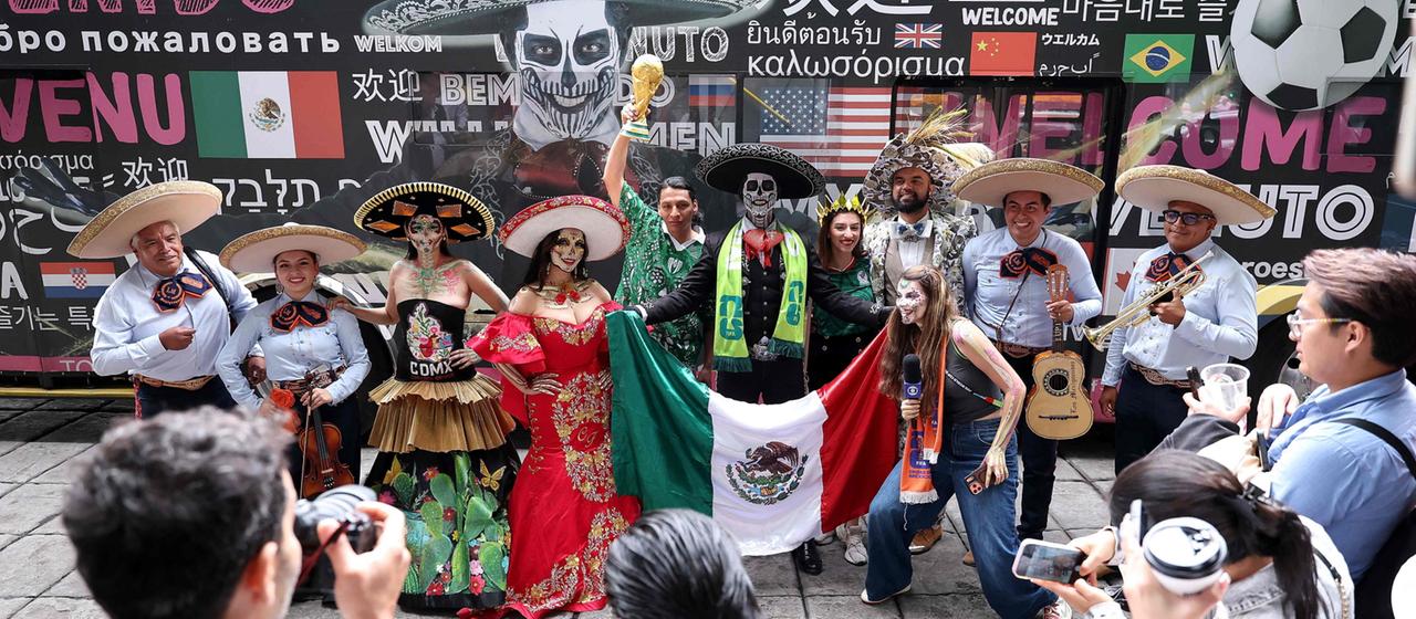 Costumed people pose with soccer fans in Mexico