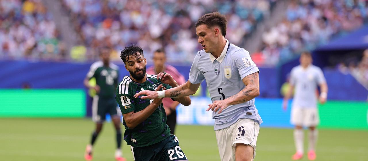 Saudi Arabia's Mohammed Abu Al Shamat in action against Hassan Tambakti of Uruguay