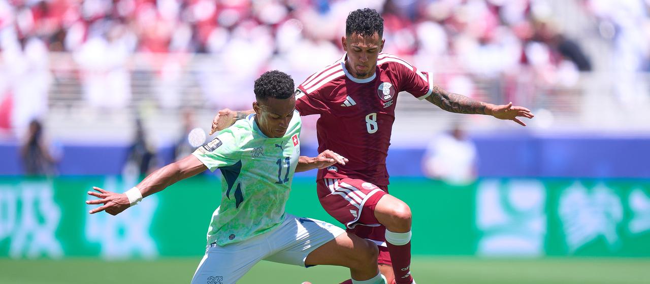 Qatar's Edmílson Junior (r.) tries to take the ball from Switzerland's Dan Ndoye