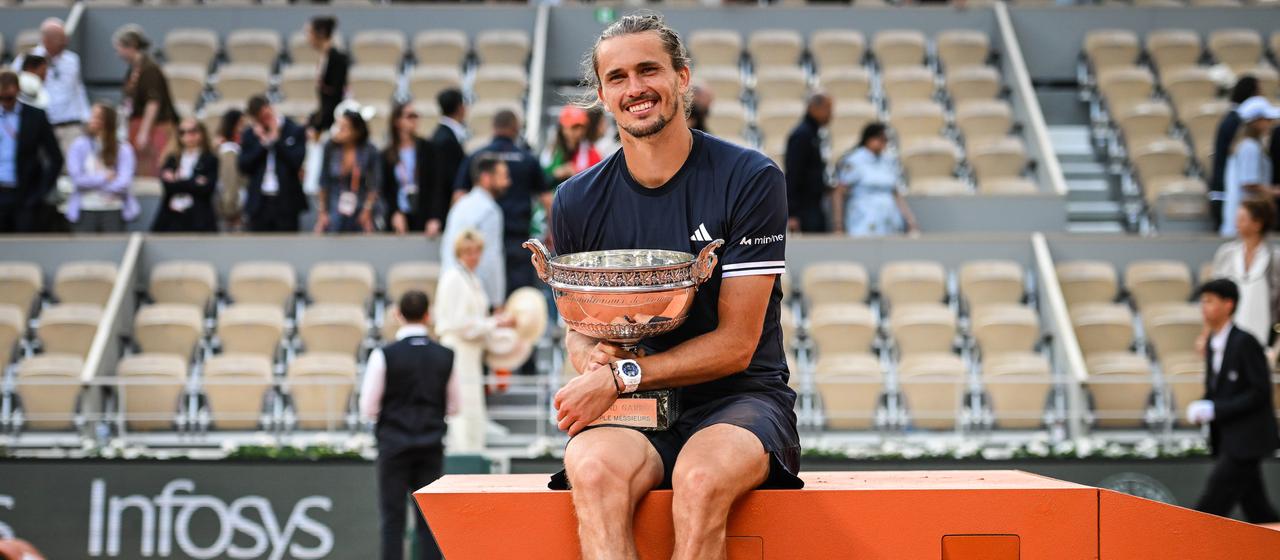 Alexander Zverev sits on the winner's plateau with the trophy