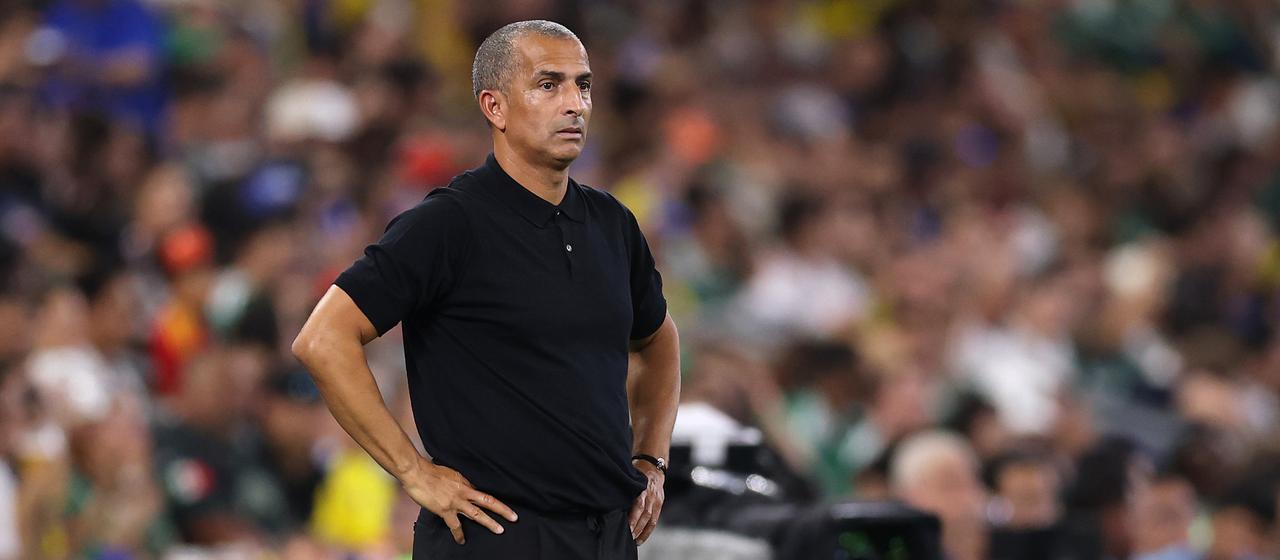 Sabri Lamouchi stands on the sidelines during the game against Sweden