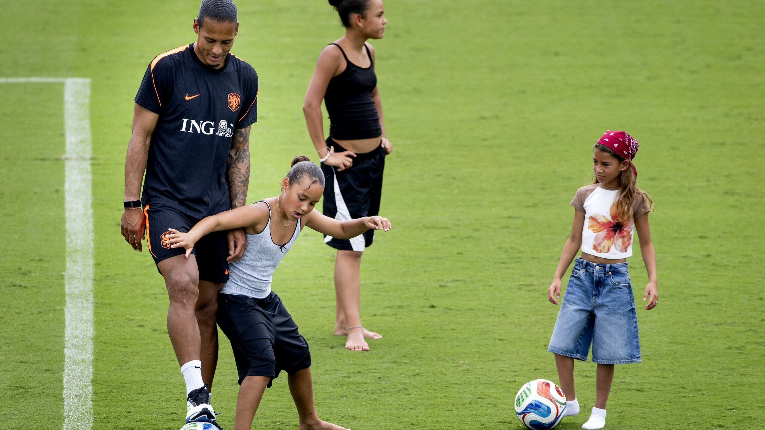 Players of the Dutch national team have fun with their children after training for the match against Japan