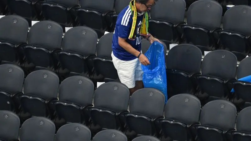 Japanese fans clean up the rubbish in the stadium after the World Cup Group F match. Japanese fans clean up the rubbish in the stadium after the World Cup Group F match.