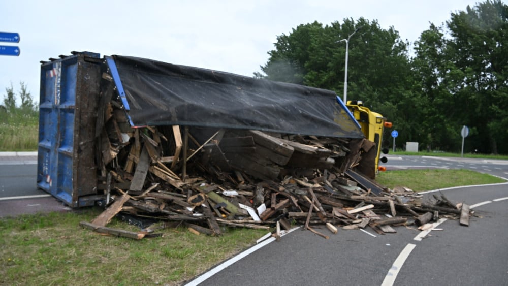 Truck with wood overturned on roundabout near Winkel, road closed