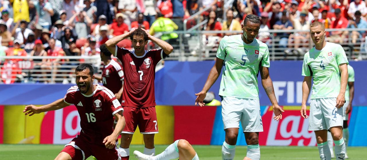 Qatar's Boualem Khoukhi (l.) celebrates while the Swiss players look down in disappointment